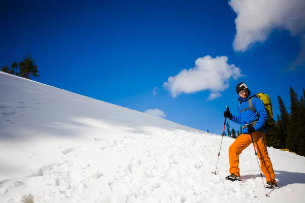 Escalador de montaña camina en una ladera nevada . —  Fotos de Stock