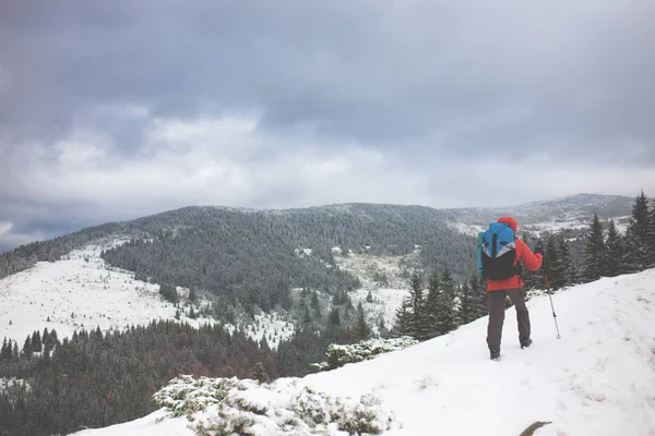 Dağlarda kar üzerinde yürüyen sırt çantası ile kız. — Stok fotoğraf