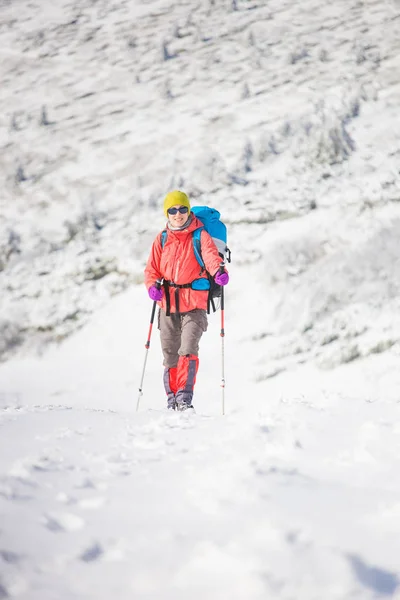 Menina com mochila andando na neve nas montanhas . — Fotografia de Stock