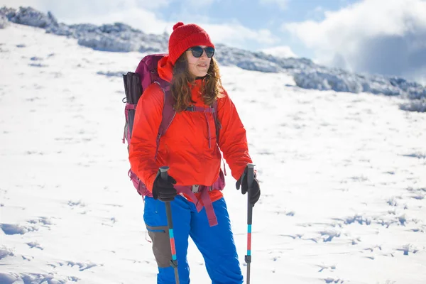 Menina com mochila andando na neve nas montanhas . — Fotografia de Stock