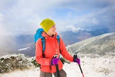 Dağlarda kar üzerinde yürüyen sırt çantası ile kız.