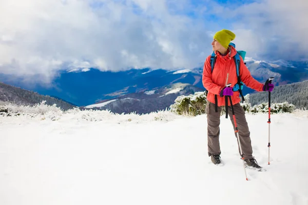 Fille avec sac à dos marchant sur la neige dans les montagnes . — Photo