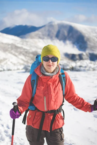 Chica con mochila caminando en la nieve en las montañas . — Foto de Stock