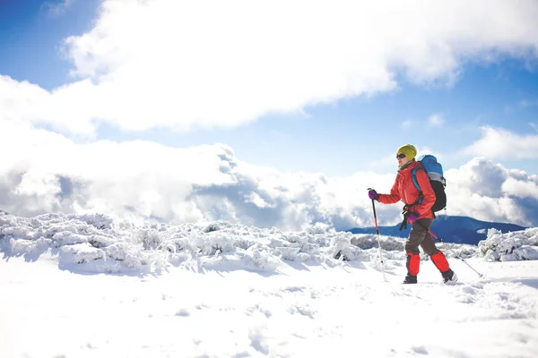 山の雪の上を歩いてのバックパックを持つ少女. — ストック写真