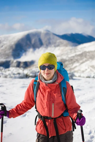 Menina com mochila andando na neve nas montanhas . — Fotografia de Stock