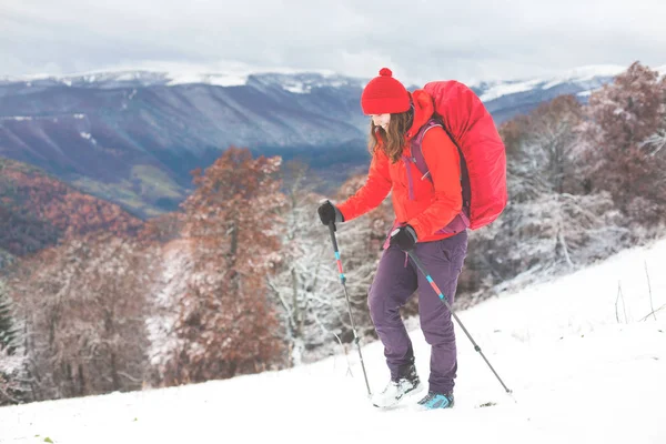 Menina com mochila andando na neve nas montanhas . — Fotografia de Stock