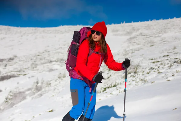 Menina com mochila andando na neve nas montanhas . — Fotografia de Stock