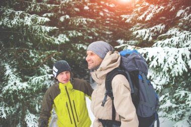 Arkadaş grubu kış ormanında sırt çantaları.