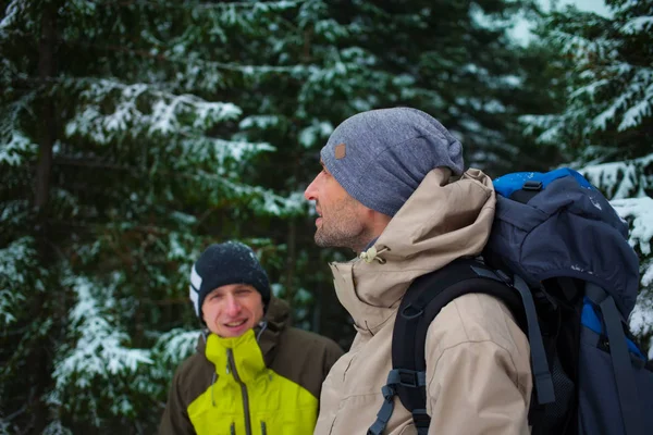 Freunde mit Rucksäcken im Winter im Wald. — Stockfoto