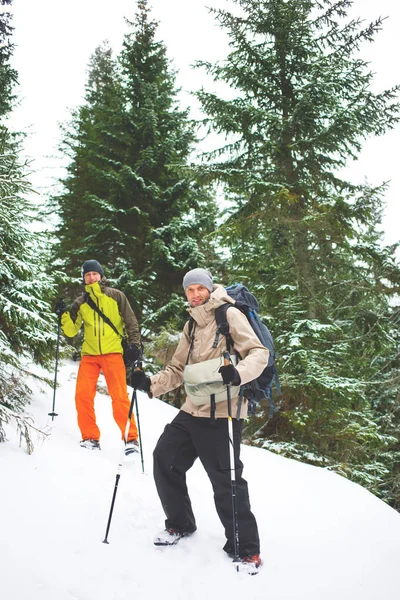 Amigos con mochilas en las montañas en invierno . — Foto de Stock