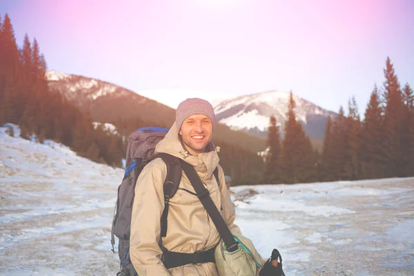 Un hombre es fotografiado en el fondo de montañas nevadas . — Foto de Stock