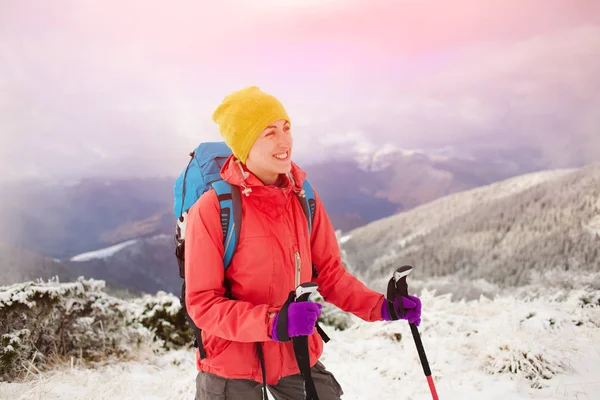 Dağlarda kar üzerinde yürüyen sırt çantası ile kız.