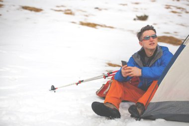 Bir adam bir çadırda kışın oturuyor..