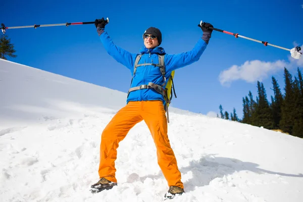 トレッキング ポールが男は山で雪の中を行く. — ストック写真