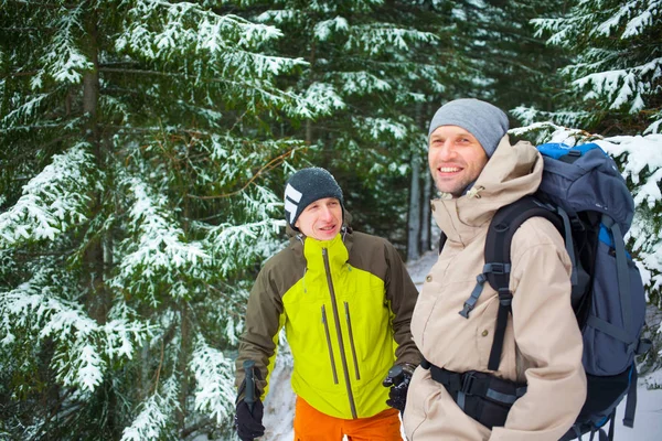 Vrienden met rugzakken in het bos in de winter. — Stockfoto