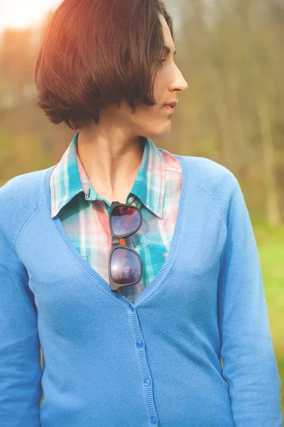 Девушка в клетчатой рубашке и голубом кардигане . — стоковое фото
