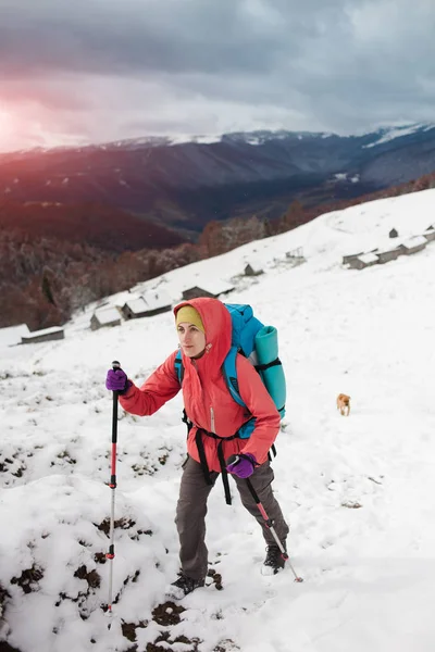 Menina com mochila andando na neve nas montanhas . — Fotografia de Stock