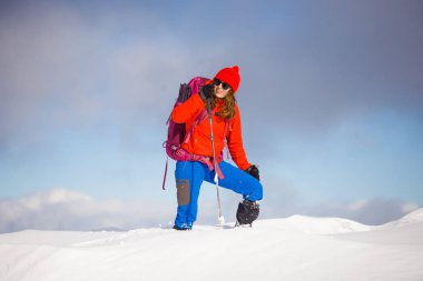 Dağlarda kar üzerinde yürüyen sırt çantası ile kız.