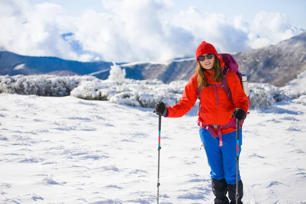 Chica con mochila caminando en la nieve en las montañas . — Foto de Stock