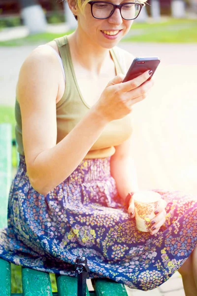 Молодая женщина смотрит на мобильный телефон . — стоковое фото