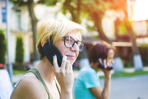 携帯電話で話しているスタイリッシュなサングラスの若い女性. — ストック写真