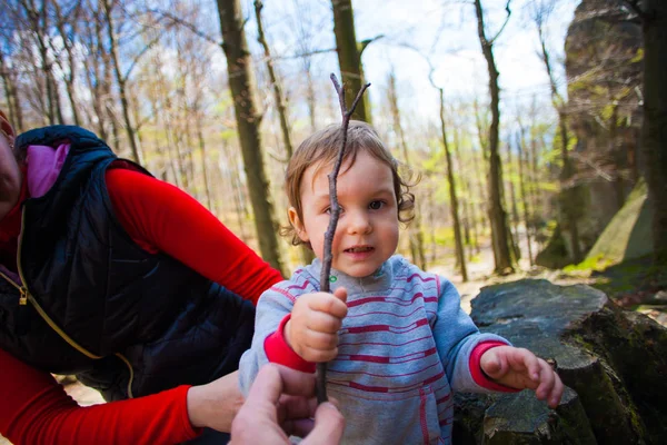 Menino brinca com um pau de madeira . — Fotografia de Stock