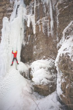 Dağcı buza tırmanıyor.