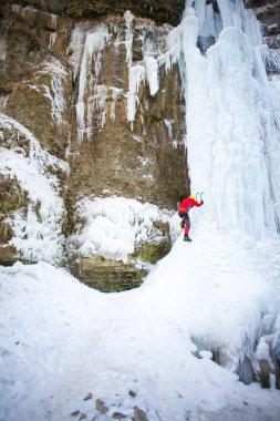 Dağcı buza tırmanıyor.