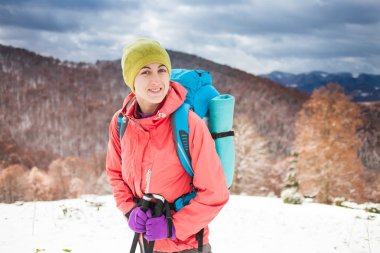 Dağlarda kar üzerinde yürüyen sırt çantası ile kız.