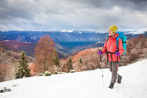 Menina com mochila andando na neve nas montanhas . — Fotografia de Stock