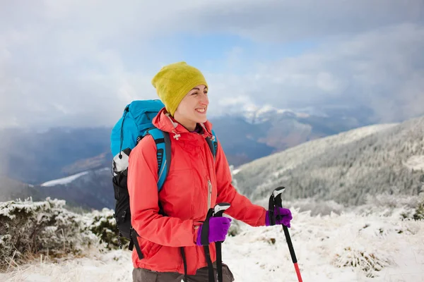 Meisje met rugzak lopen op sneeuw in de bergen. — Stockfoto