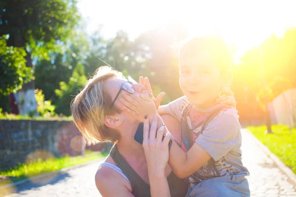 En kvinna håller son på händer. — Stockfoto