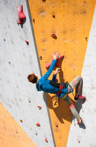 La fille grimpe sur le mur d'escalade . — Photo