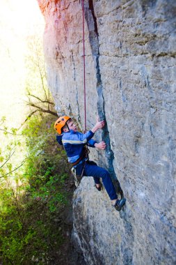 Çocuk kaya tırmanışçısı uçurumun tırmanıyor.