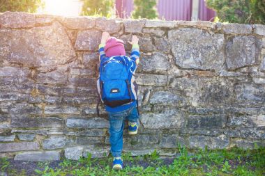 Bir çocuk bir çit tırmanıyor.