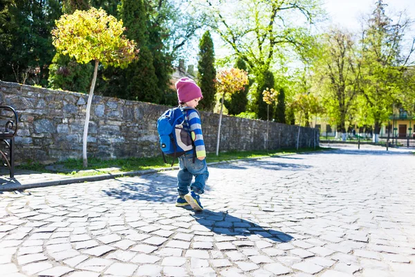 Ein Junge mit Rucksack läuft über die Straße. — Stockfoto