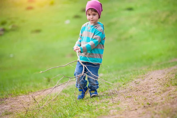 Un niño camina por un prado . —  Fotos de Stock