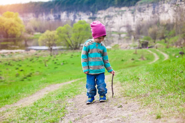 Un niño camina por un prado . — Foto de Stock