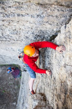 Tırmanıcı bir kask içinde yukarı tırmanıyor.