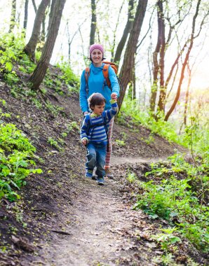 Çocuk ve annesi ormana doğru yürüyor.