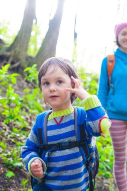 Çocuk ve annesi ormana doğru yürüyor.