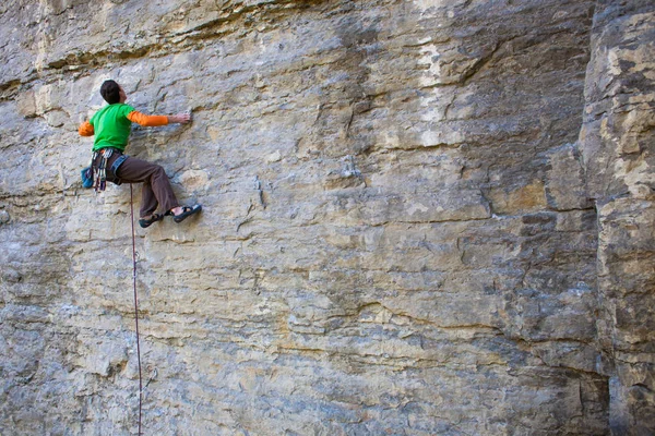 Альпинист взбирается на скалу — стоковое фото
