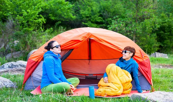 two girls having fun near the tent camping