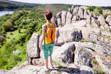 Kız bir sırt çantası ile pitoresk yerlerde yürür.