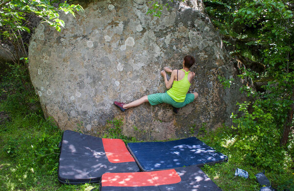 Climber is bouldering outdoors.