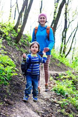 Çocuk ve annesi ormana doğru yürüyor.