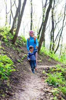 Çocuk ve annesi ormana doğru yürüyor.