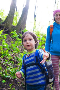 Çocuk ve annesi ormana doğru yürüyor.