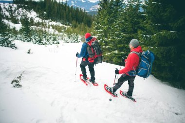 Kışın dağlarda iki dağcı.