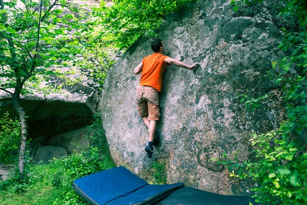 Der Bergsteiger klettert Bouldern. — Stockfoto